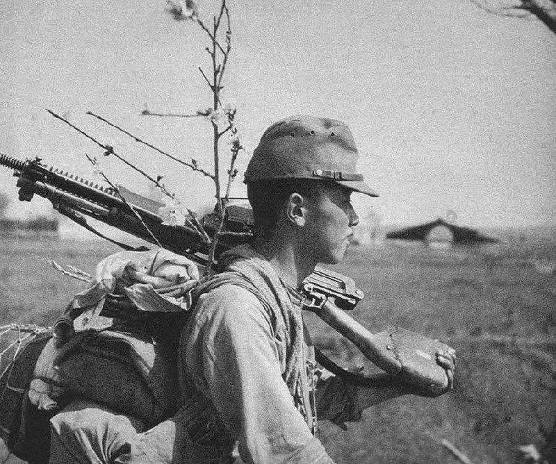 一张1940年代拍摄的照片，画面中是一名日本士兵在中国战场上，肩扛十一年式轻机枪（Type 11 machine gun）