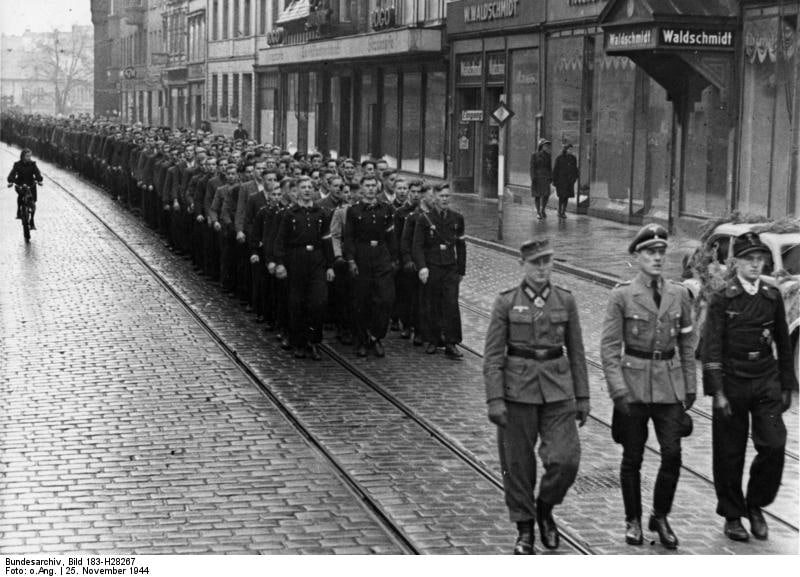 1944年11月25日，一群希特勒青年团成员在德国某城市游行，前往报名参军