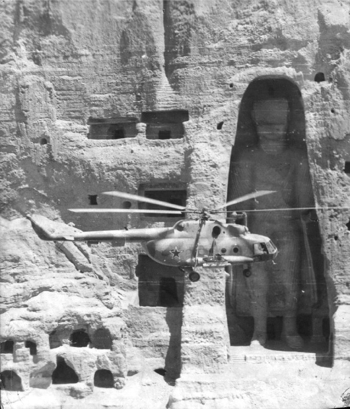 苏联Mi-8飞越阿富汗巴米扬大佛，1980年阿富汗巴米扬大佛是两尊巨大的佛像，曾经矗立在巴米扬峡谷的悬崖上，分别高约55米和38米，建于6世纪左右，是古代丝绸之路上的重要佛教艺术遗产