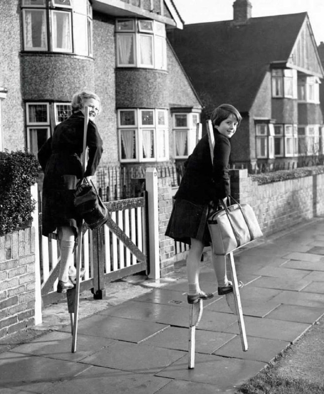 1950年英国，两个踩高跷的女孩，当时踩高跷是孩子们很喜欢的游戏