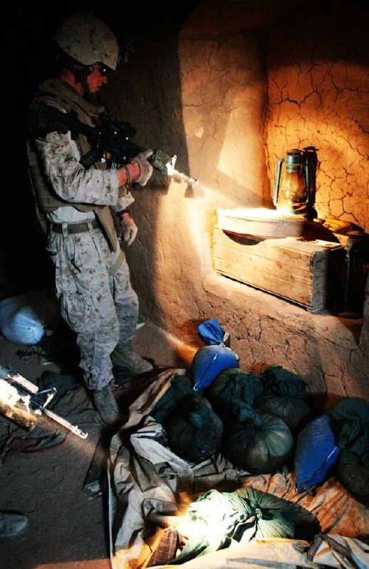 2009年7月30日，阿富汗赫尔曼德省——美国海军陆战队士兵在一次缉毒行动中，搜查村庄里的一处院落