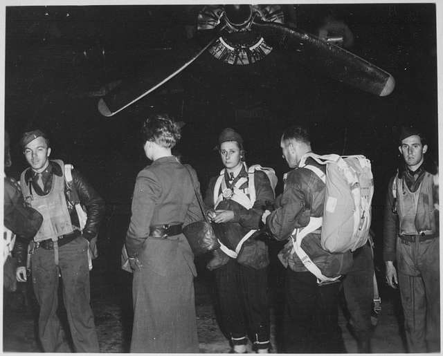 1944年：Jedburgh特遣队在英格兰哈灵顿机场的B-24轰炸机前准备夜间起飞这张历史照片拍摄于二战期间，地点是英国哈灵顿机场（Harrington Airdrome），展示了Jedburghs特遣队在一架B-24轰炸机前准备执行夜间任务的场景