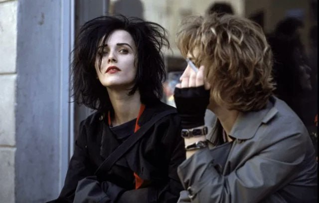 20 世纪 80 年代末，两名女子坐在南斯拉夫贝尔格莱德市的一家店面旁边