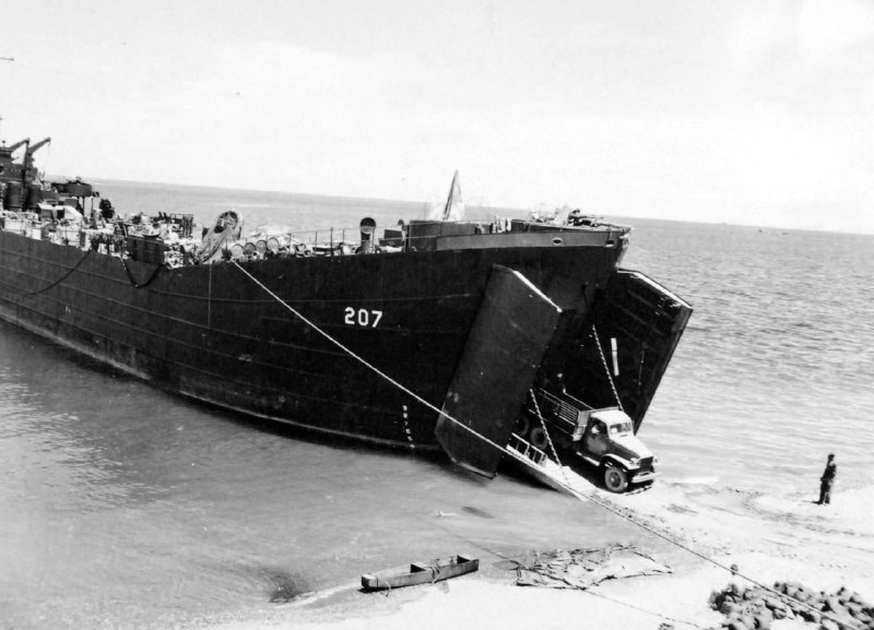 美国海军登陆舰 LST-207，由美国海岸警卫队人员操作，于1943年11月26日停靠在所罗门群岛瓜达尔卡纳尔岛的库库姆海滩