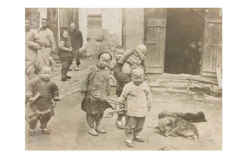 1908年，杭州，手拿板凳的几个孩子和地上躺着的两条狗