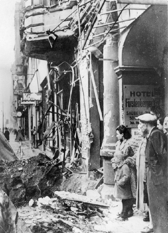 1940年，路人们看着路上的大坑，这是英国空袭柏林造成的