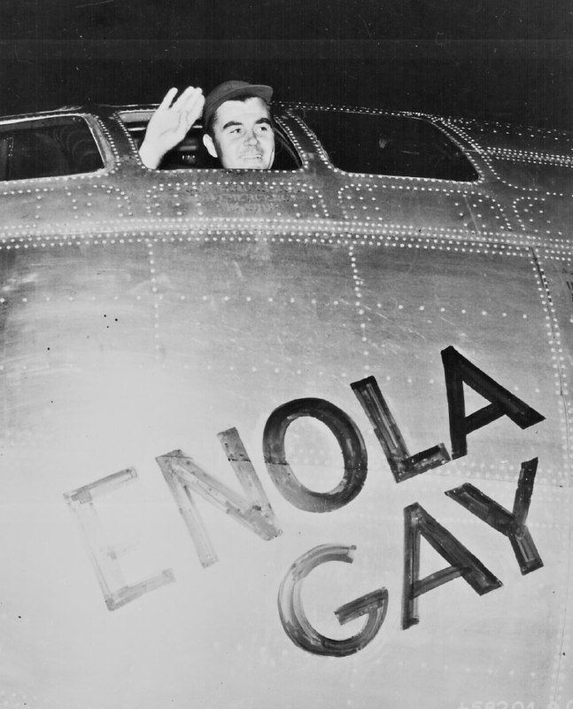 1945 年 8 月 6 日，在广岛投下原子弹的 ENOLA GAY 飞机的飞行员小保罗·W·蒂贝茨 (Paul W. Tibbets, Jr.) 从他的驾驶舱挥手致意，起飞前