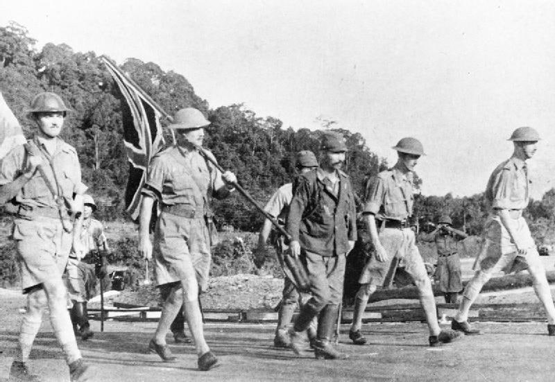 1942年2月15日，在杉田一二的带领下，亚瑟·珀西瓦尔中将（右）在停战旗帜下行走，以谈判英联邦军队在新加坡的投降