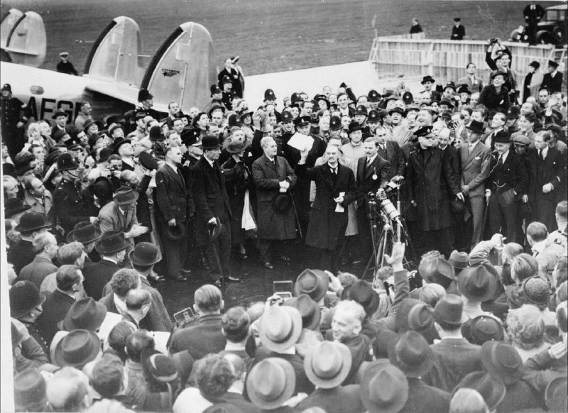 1938年9月30日，英国首相张伯伦在机场对群众挥舞着与希特勒签署的和平协定