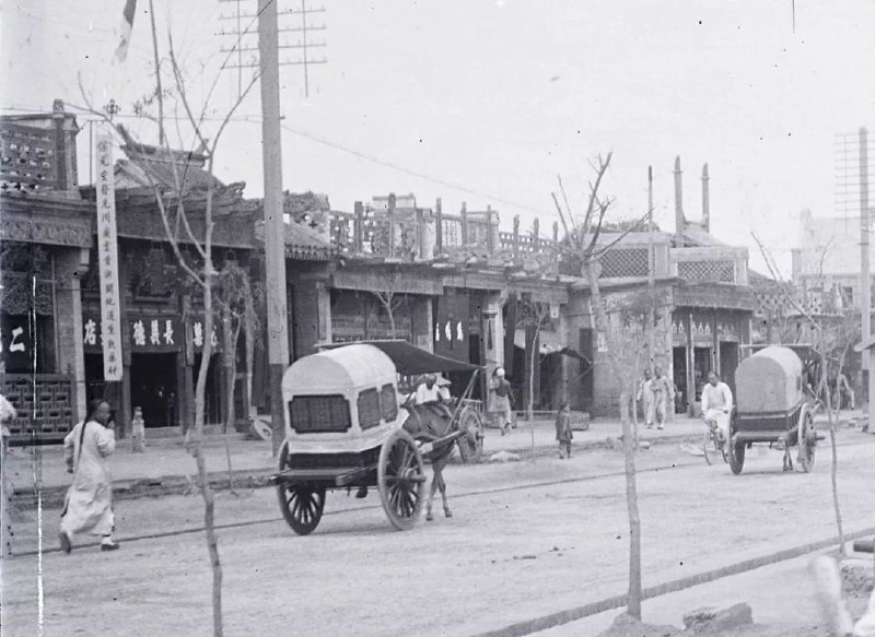 1905 年左右，北京东单北大街，骑自行车的人与行人、马车并行