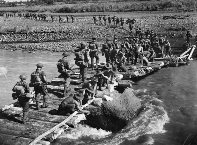 图为1943 年 10 月 25 日，澳大利亚军队正在穿过古萨普河上的一座桥
