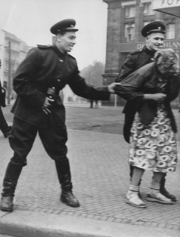 1945 年，德国领土沦陷，苏联士兵在德国莱比锡骚扰一名妇女