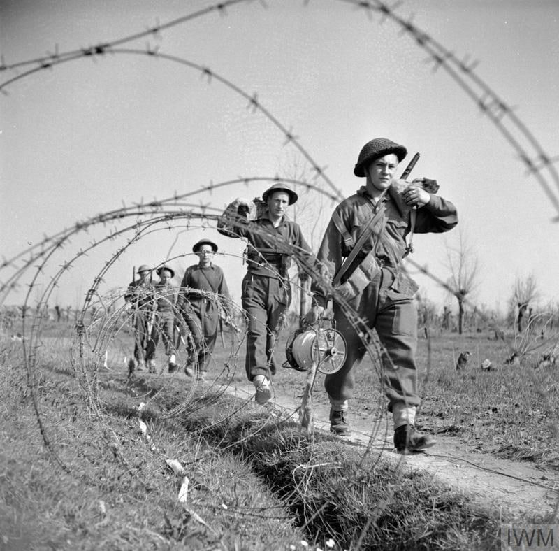 1945年3月22日，第2伦敦爱尔兰步枪队“H”连第17排的士兵们穿过铁丝网防线前进，准备攻击意大利塞尼奥河南岸的德军据点