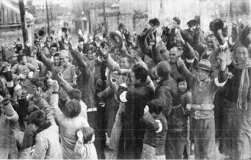 1937年12月15日，南京，在日军“入驻南京仪式”当天，正在领取糖果和香烟的难民为日军欢呼
