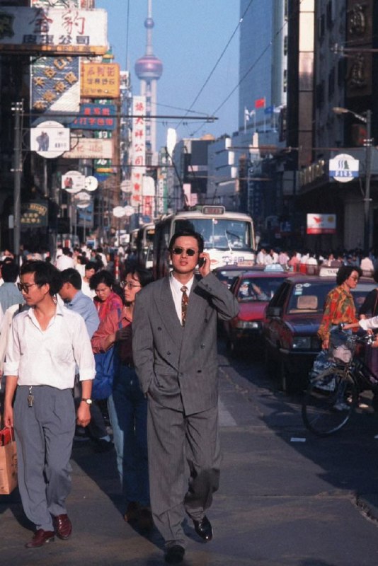 1995年，上海，一名男子在街上使用着爱立信337手机