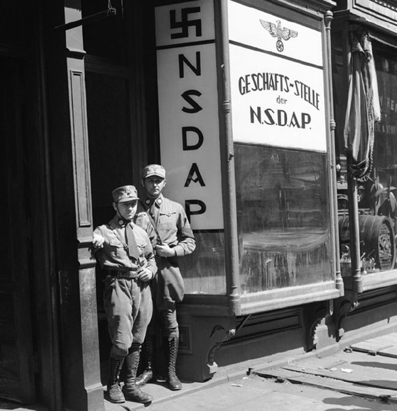 1932年4月1日，在纳粹党美国总部成立之日，两位穿着制服的美国纳粹分子在在纽约的办事处门口