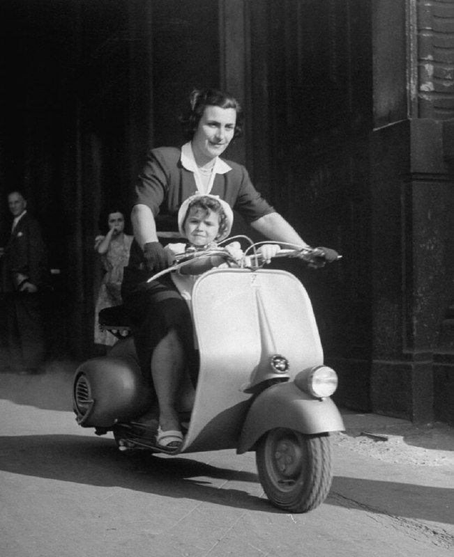 1948 年，母亲和婴儿在意大利骑着 Vespa 踏板车