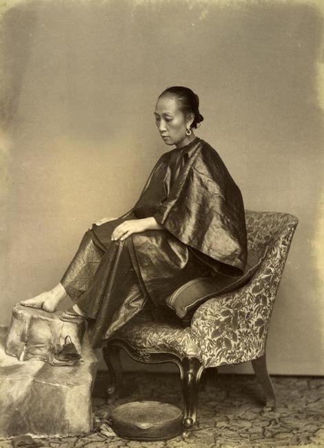 1870年代，一位中国妇女展示她的脚（缠足）