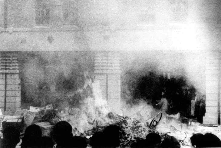 1947年2月28日，#台湾，群众聚集专卖局台北分局门前，将专卖局所存的香烟、酒、火柴各种货品抛到路上，连同停在一旁的脚踏车放火焚烧泄愤