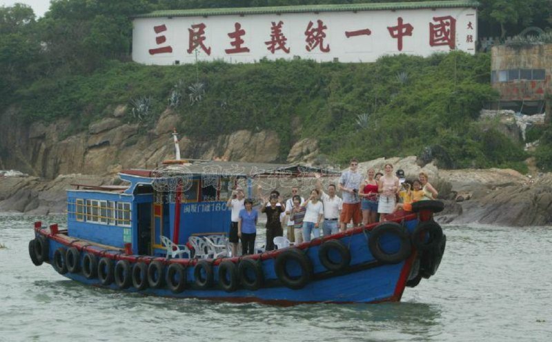 2002年，一条厦门渔船载着游客参观“三民主义统一中国”标语