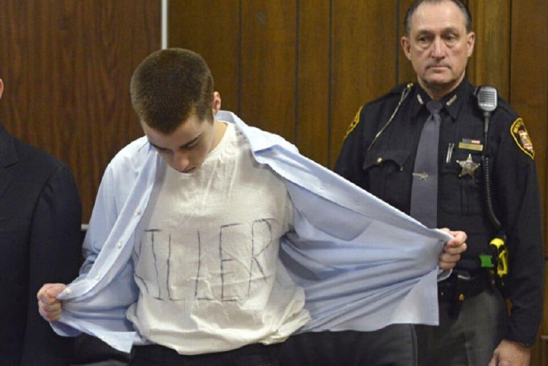 转自【老照片bot】：2012年2月27日上午，十七岁的T.J.莱恩在查登高中的自助餐厅开枪，打死3名学生，打伤3人，当时他穿着印有“杀手”字样的运动衫