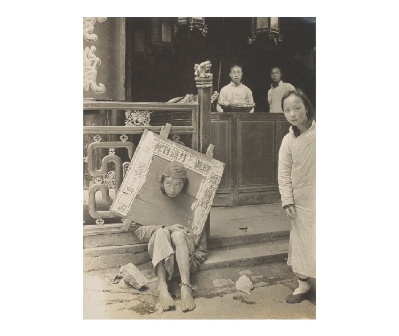 1908年，浙江杭州，戴枷的罪犯坐在台阶上