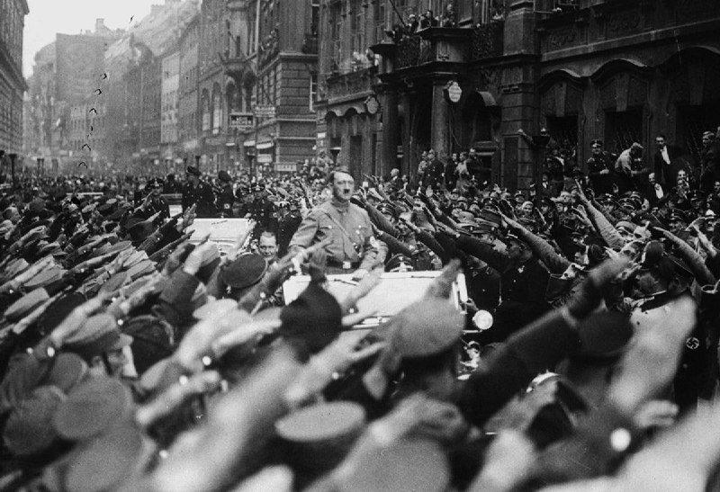 1933年11月3日，在庆祝德国国家社会主义运动创立十周年的日子里，阿道夫希特勒的车队行进在慕尼黑的街道上，接受来两旁亲纳粹分子的欢迎和敬礼