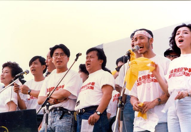 1989年5月27日，民主歌声献中华 (英语：Concert For Democracy In China）是香港市民为支持北京八九民运而举办的筹款活动，在跑马地马场举行，无线电视翡翠台、亚洲电视本港台、香港电台第一台、香港商业电台商业一台联合现场直播