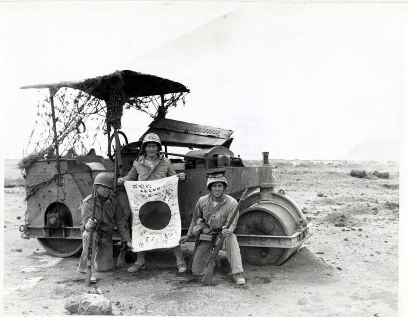 1945 年 2 月，三名美囯海军陆战队军士在硫磺岛展示缴获的日本国旗