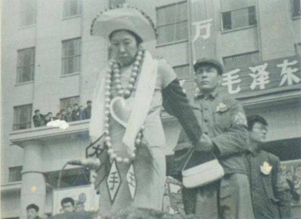 图为1967年4月10日文革，刘少奇夫人王光美穿旗袍、戴乒乓球项链，被拱上批斗大会