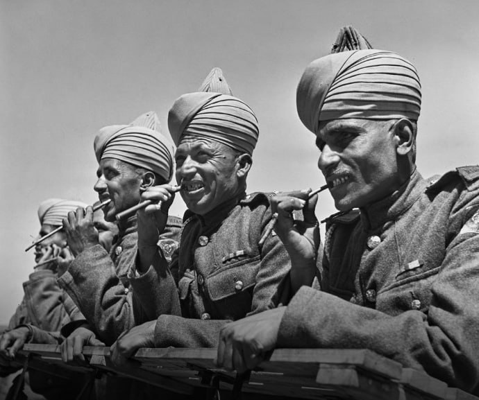 1942 年 5 月：二战期间，在英格兰西部的一个军营中，英属印度陆军的一部分，皇家印度陆军服役团的士兵用木棍的末端清洁他们在营地外的牙齿