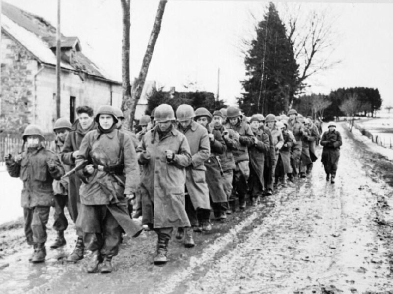 1944年12月在阿登战役期间被德军俘虏的美国士兵被押送在道路上的场景