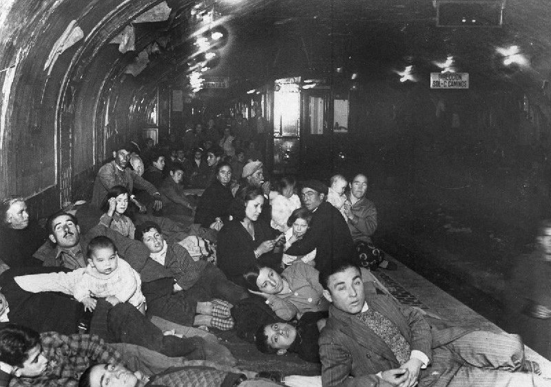 #西班牙内战1936年12月9日，在弗朗哥的军队飞机在头顶上空投下炸弹时，许多家庭躲藏在马德里地铁站的地下平台上的场景